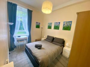 a bedroom with a bed with a cat laying on it at Paisley Pad Glasgow Gateway second floor flat in Paisley