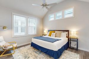 ein Schlafzimmer mit einem Bett und zwei Fenstern in der Unterkunft Mercer Village at Old Town #3B in Port Aransas + 14 Fotos