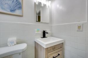 ハリウッドにある3 Mi to Beach Quaint Home with Patio in Hollywoodの洗面台と鏡のある白いバスルーム +16枚の写真