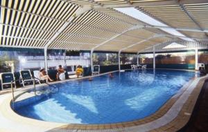 una grande piscina con persone sedute intorno di Hotel Gemma a Ischia