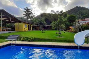 a house with a yard with a swimming pool at Sítio recanto do Saltinho Santa teresa -ES in Santa Teresa
