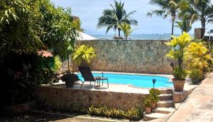 a pool with a chair and a laptop next to a wall at Hotel Mar y Mar in Puntarenas