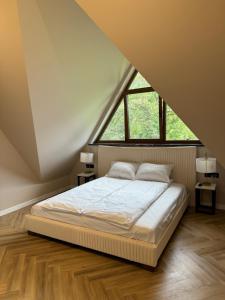 a bedroom with a bed and a large window at Yeti Apartamenty Krupówki 73C in Zakopane