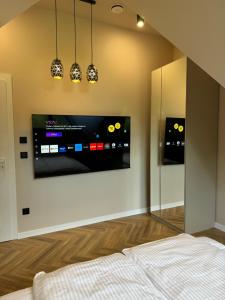 a bedroom with a flat screen tv on a wall at Yeti Apartamenty Krupówki 73C in Zakopane