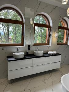 a bathroom with two sinks and two windows at Yeti Apartamenty Krupówki 73C in Zakopane +18 photos