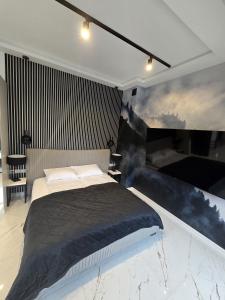 a bedroom with a bed and a painting on the wall at Yeti Studio Apartament Krupówki 73C in Zakopane