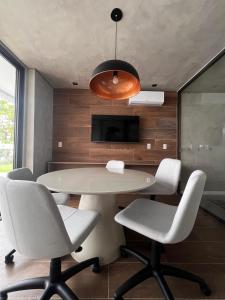 una sala da pranzo con tavolo e sedie bianchi di Studio disponível na Barra Salvador Ba a Salvador