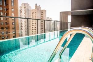 圣保罗Cozzy Suites Paraíso Hotel的建筑物屋顶上的游泳池