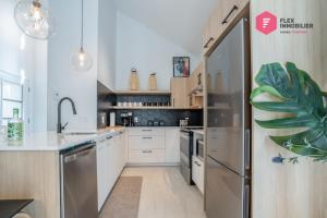 a kitchen with white cabinets and a stainless steel refrigerator at La Casa Bella - Luxury, Comfort, Pool & private SPA in Valcartier Station