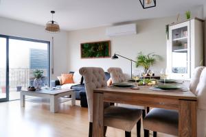a living room with a dining room table and a couch at Spacious terrace, swimming pool, private parking in Olhão