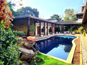 a house with a swimming pool in the yard at A Casa do Sol Ilhabela in Ilhabela