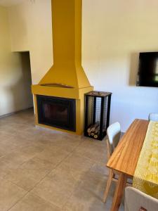 a living room with a fireplace with a table and chairs at Casa Rondinella de Bodega Masi in Tupungato