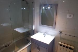 Un baño con lavabo, ducha y espejo. en Casa Maximo en Vigo con Patio y Aparcamiento, en Vigo