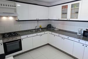 Una cocina blanca con gabinetes blancos y un fregadero. en Casa Maximo en Vigo con Patio y Aparcamiento, en Vigo 9 fotos más