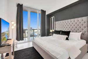 a bedroom with a large bed and a large window at Penthouse Sky Suite - 2BDR2BTH - Private Rooftop Terrace in Hallandale Beach