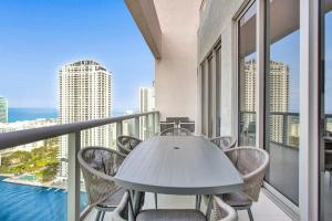a table and chairs on a balcony with a view of the ocean at Penthouse Sky Suite - 2BDR2BTH - Private Rooftop Terrace in Hallandale Beach
