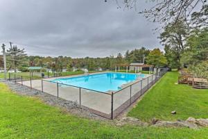 a swimming pool with a fence around it at Pet Friendly! Lakefront w Hot Tub, Firepit! in Tobyhanna