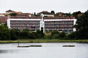 ein großes Gebäude mit zwei Booten im Wasser in der Unterkunft Apartamentos Bahía de Boó in Guarnizo