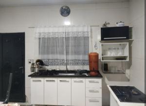 eine weiße Küche mit Spüle und Fenster in der Unterkunft Casa Refugio in Alto Paraíso de Goiás + 9 Fotos