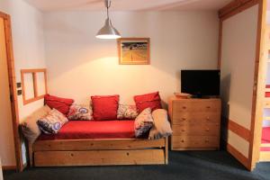 un salon avec un canapé rouge et une télévision dans l'établissement Résidence Eskival - ESKIVAL APPARTEMENT 35M² 4 PERS CENTRE STATION ACCES DIRECT SUR LES PISTES MAE-7711, à Val Thorens 10 autres photos