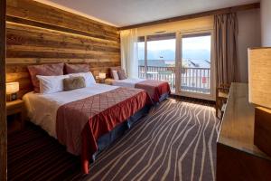 a hotel room with two beds and a balcony at Hôtel Le Grand Tétras in Font-Romeu +58 photos