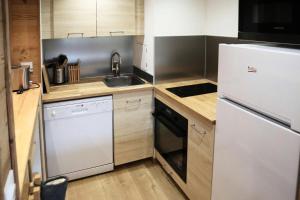 kuchnia z białą lodówką i zlewem w obiekcie Résidence Le Silhourais - 56 SILHOURAIS : Appartement 2 pièces pour 6 personnes MAE-0794 w mieście Le Mélézet +7 zdjęć
