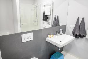 ソポトにあるAquarius Apartmentの白いバスルーム(シンク、シャワー付)