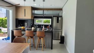 une cuisine avec un îlot et des tabourets de bar dans l'établissement Verão Relaxante no Condomínio Las Palmas, à Xangri-lá 8 autres photos