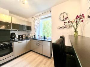 une cuisine avec une table et une horloge au mur dans l'établissement Comfort Home, à Olsztyn