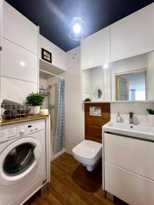 une salle de bains avec lave-linge et lavabo dans l'établissement Comfort Home, à Olsztyn