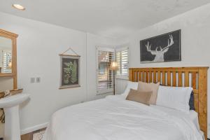 a white bedroom with a bed and a sink at Ski In out Remodeled Luxury Condo in Telluride +8 photos
