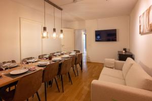 Munich Large Apartment 110 qm, 3 Bedrooms and very Central 1-12 Guests في ميونخ: غرفة طعام طويلة مع طاولة طويلة وكراسي