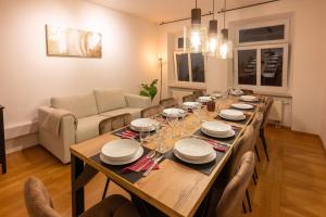 Munich Large Apartment 110 qm, 3 Bedrooms and very Central 1-12 Guests في ميونخ: طاولة خشبية طويلة في غرفة المعيشة