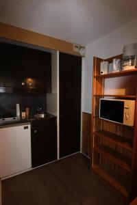een kleine keuken met een spoelbak en een magnetron bij Résidence Roche Blanche - VAL THORENS STUDIO 2 PERSONNES CENTRAL MAE-7793 in Val Thorens