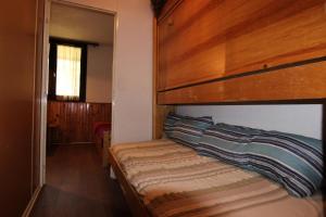 een slaapkamer met een stapelbed en een houten hoofdeinde bij Résidence Roche Blanche - VAL THORENS STUDIO 2 PERSONNES CENTRAL MAE-7793 in Val Thorens