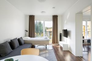 un salon avec un canapé et un lit dans l'établissement Hiisi Homes Vantaa Kulomäki, à Jokivarsi