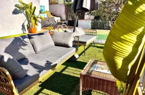 a patio with a couch and a table and a plant at SeaHomes Vacations, LA CASA BLUE Mediterranean Lifestyle in Blanes