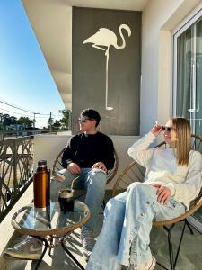 a man and woman sitting in chairs on a balcony at Roseus Hotel Boutique in Miramar