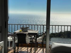 a table and chairs on a balcony with a view of the ocean at SeaHomes Vacations, LA CASA BLUE Mediterranean Lifestyle in Blanes