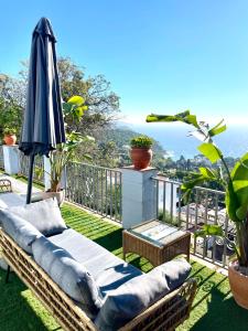 a patio with an umbrella and chairs on a balcony at SeaHomes Vacations, LA CASA BLUE Mediterranean Lifestyle in Blanes