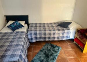 two twin beds in a room with a rug at B&B La Casa D Ju Nan in Bussi sul Tirino