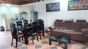 a living room with a couch and a table and chairs at ALOJAMiENTO RURAL LA BELLA ALCUDIA in Quimbaya