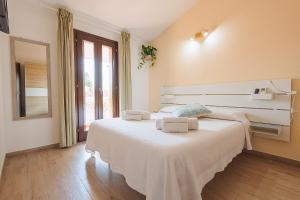 ein Schlafzimmer mit einem großen weißen Bett, auf dem Handtücher liegen in der Unterkunft Pothos Apartment, Relax in Sardegna in Terralba
