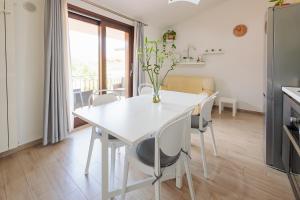 eine Küche und ein Esszimmer mit einem weißen Tisch und Stühlen in der Unterkunft Pothos Apartment, Relax in Sardegna in Terralba