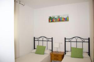 zwei Betten mit grünen Kissen in einem Zimmer in der Unterkunft Apartamento COLOM I Peñiscola in Peñíscola