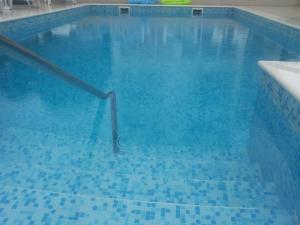 a blue swimming pool with a rail in the water at Villa Pincevic in Lopud Island