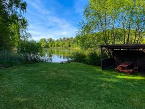 a gazebo in the grass next to a lake at Agrowczasy u Bartka in Wielki Klińcz