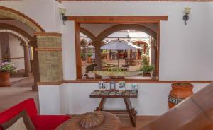 a mirror in a room with a table and a fountain at Maria Bonita Hotel in Villa de Leyva