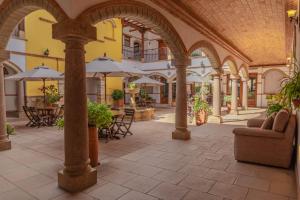 an empty courtyard with tables and umbrellas in a building at Maria Bonita Hotel in Villa de Leyva