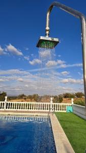 a water fountain hanging over a swimming pool at Casa Albahacar in Paymogo